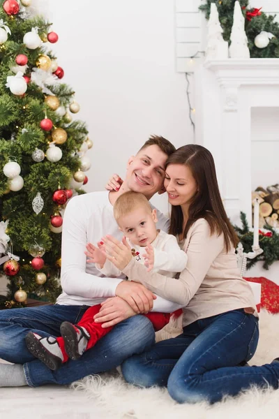 Feliz joven padres alegres con lindo hijo pequeño. Niño niño sentarse — Foto de Stock