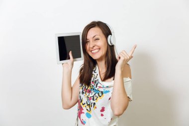 Güzel duygusal Avrupa kahverengi saçlı bir kadınla sağlıklı temiz cilt, büyüleyici smile, rahat hafif kıyafetler giymiş, dinler ve beyaz zemin üzerine tablet ile kulaklıklar müzik hoşlanır.
