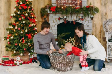 Sevimli küçük bir bebek çocuk evde bir şekilde dekore edilmiş oda ile oynak mutlu anne portresi. Noel keyfi. Yeni yıl. Yaşam tarzı, Aile ve beraberlik kavramı.
