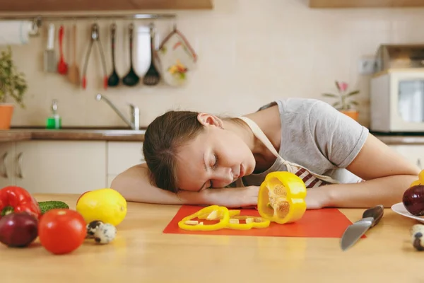 Молодая измученная уставшая женщина в фартуке спит за столом на кухне дома. Концепция диеты. Здоровый образ жизни. Готовьте еду. . — стоковое фото