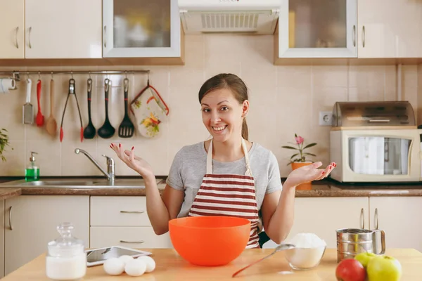 Una giovane bella donna felice prepara la pasta per le torte natalizie con tablet sul tavolo in cucina. Cucinare a casa. Preparare il cibo . — Foto Stock