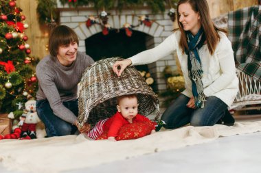 Sevimli küçük bir bebek çocuk evde bir şekilde dekore edilmiş oda ile oynak mutlu anne portresi. Noel keyfi. Yeni yıl. Yaşam tarzı, Aile ve beraberlik kavramı.