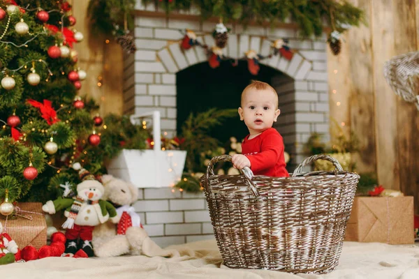 Portret figlarny happy cute baby chłopca, który siedzi w kosza w urządzony pokój w domu. Dobry nastrój Bożego Narodzenia. Nowy rok. Koncepcja życia, rodziny i Wspólnoty. — Zdjęcie stockowe