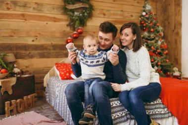 Neşeli mutlu anne ile şirin küçük bir çocuk çocuk Noel ağacı ile a oyuncak odasında bir şekilde dekore edilmiş yeni yıl ahşap evde, yatakta. İyi bir ruh hali. Yaşam tarzı, Aile ve tatil 2018 kavramı