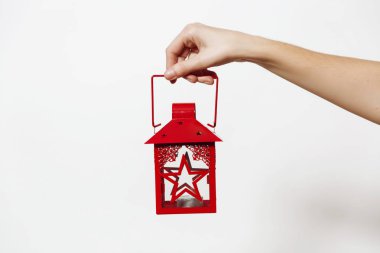Beyaz arka plan üzerinde izole şamdan ile kırmızı vintage Noel fener tutarak el. Yeni yıl tatil 2018 kavramı