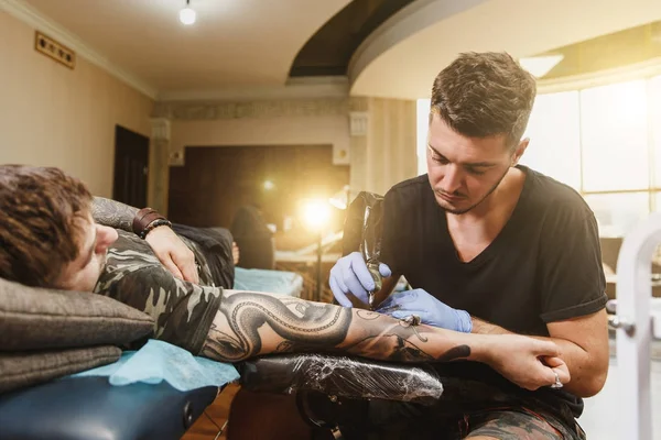 O Mestre Da Tatuagem Faz a Tatuagem Preta Na Mão Masculina Foto de Stock -  Imagem de detalhe, marca: 153497120