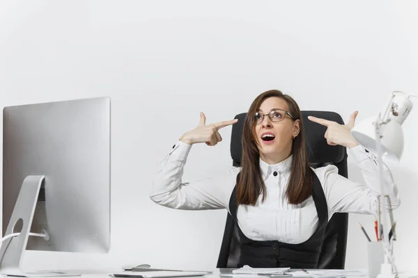 Tired perplexed and stress business woman in suit sitting at the desk, working at contemporary computer with documents, puting her hands to head like pistol for shoot in office on white background — Stock Photo, Image