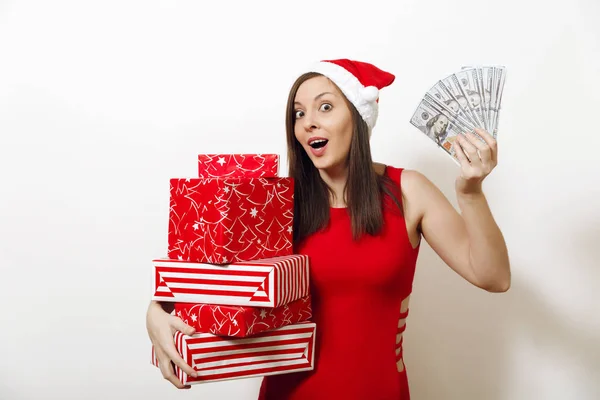 赤いドレスと白い背景の上のギフト ボックスやお金紙幣を持ってクリスマス帽子かなり白人若い幸せな女。プレゼント サンタ少女と分離された現金。新年休日 2018 コンセプト — ストック写真