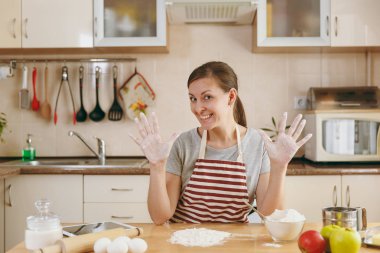 Bir Noel mutfakta kek hazırlamak için un ile bir masada oturan ve gidiş genç güzel mutlu bir kadın. Pişirme ev. Yemek hazırlamak.