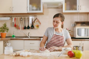 Bir Noel mutfakta kek hazırlamak için un ile bir masada oturuyor, hamur yoğurma ve gidiş genç güzel mutlu bir kadın. Pişirme ev. Yemek hazırlamak.