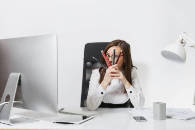 Işık Office belgeleri ile modern monitörle bilgisayarda çalışan güzel gülümseyen brown-iş kadın takım elbise ve masa başında oturan gözlük beyaz zemin üzerine kalem arkasına saklanmış