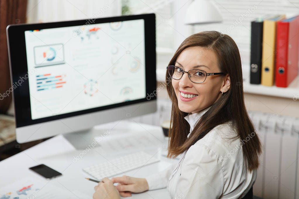 Beautiful smiling brown-hair business woman in suit and glasses 