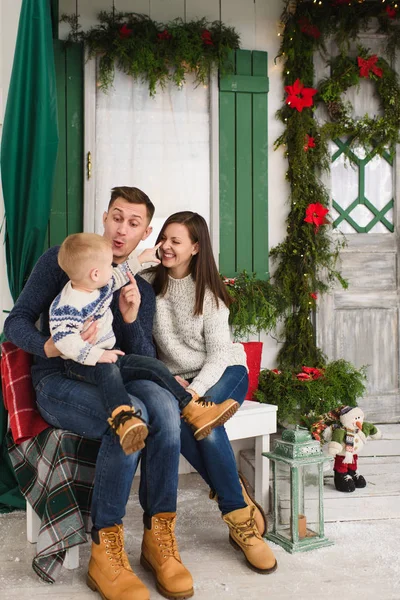 Glückliche Eltern mit kleinem Sohn. Junge im Pullover sitzt auf B — Stockfoto