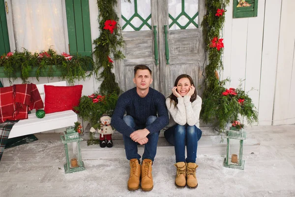 Happy funny young couple in love dressed in sweater sitting on p — Stock Photo, Image