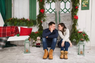 Aşık p üzerinde oturan Kazak giymiş mutlu komik genç Çift