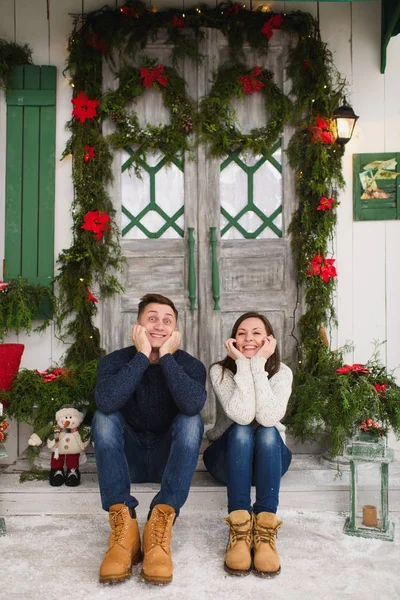 Happy funny young couple in love dressed in sweater sitting on p — Stock Photo, Image