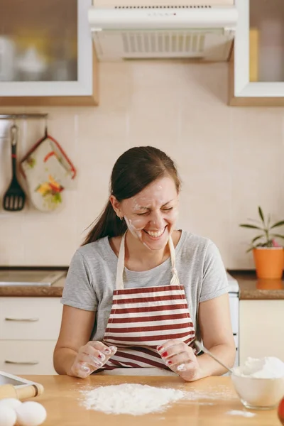 Молодая веселая веселая женщина, сидящая за столом с мукой и готовящая рождественские торты на кухне. Готовлю дома. Готовьте еду. . — стоковое фото