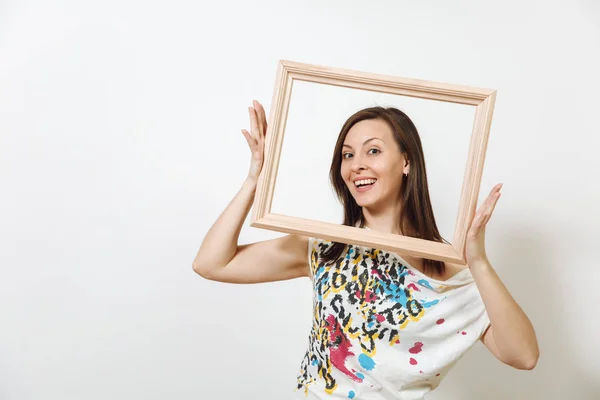 Retrato de una feliz mujer morena sonriente de pie y sosteniendo un marco de madera vacío sobre el fondo blanco . —  Fotos de Stock