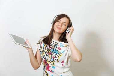 Güzel duygusal Avrupa kahverengi saçlı bir kadınla sağlıklı temiz cilt, büyüleyici smile, rahat hafif kıyafetler giymiş, dinler ve beyaz zemin üzerine tablet ile kulaklıklar müzik hoşlanır.