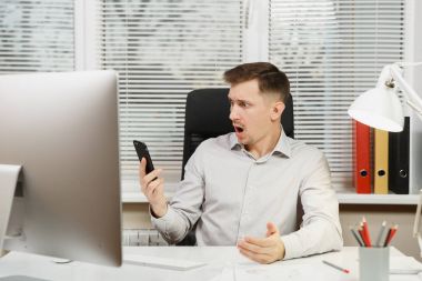 Çalışma ile modern sınıf başkanı bilgisayar, ışık office belgelerinde, sorunlarını, Masa başında oturan gömlek konuşmak, küfür ve üstünde hareket eden telefon, çığlık ciddi kızgın stres iş adamı çözme.