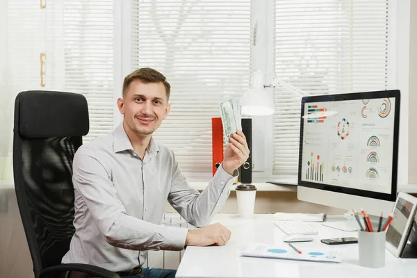 Yakışıklı gülümseyen iş adamı ile masada oturan gömlek 