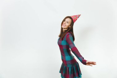 Güzel beyaz eğlenceli kutluyor ve zevk mutlu kadın ekose elbise ve doğum günü parti şapkası utangaç çekici gülümseme ve kahverengi saç, tatil için reklam izole beyaz arka plan üzerinde.