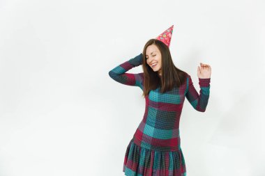 Güzel beyaz eğlenceli kutluyor ve zevk mutlu kadın ekose elbise ve doğum günü parti şapkası utangaç çekici gülümseme ve kahverengi saç, tatil için reklam izole beyaz arka plan üzerinde.