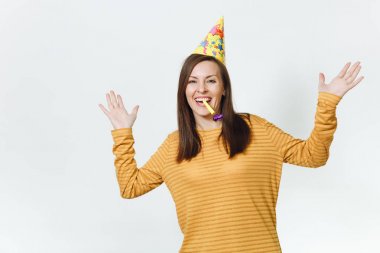 Güzel beyaz eğlenceli boru oynarken, tatil kutluyor, eller için reklam izole beyaz arka plan üzerinde yayılan genç mutlu kadın sarı giysiler ve doğum günü parti şapkası kahverengi uzun saçlı.
