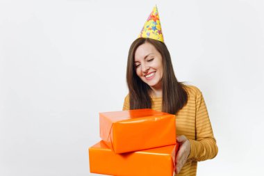 Güzel beyaz eğlenceli kutluyor ve reklam için izole beyaz arka plan üzerinde tatil keyfini mutlu kadın sarı giysili turuncu hediye kutuları ile mevcut, holding doğum günü parti şapkası.