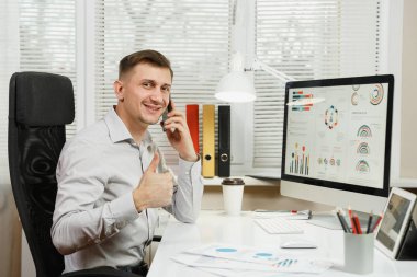 Başarılı iş adamı masa başında oturup ta gömlek gülümseyen