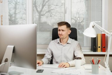 Çapraşık şok ve bilgisayarda çalışan modern monitör, klasörler, lamba, belge penceresi arka plan üzerinde ışık Office ile iş adamı masa başında oturan gömlek stres. Yöneticisi veya alt.