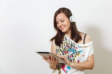 Güzel duygusal Avrupa kahverengi saçlı bir kadınla sağlıklı temiz cilt, büyüleyici smile, rahat hafif kıyafetler giymiş, dinler ve beyaz zemin üzerine tablet ile kulaklıklar müzik hoşlanır.