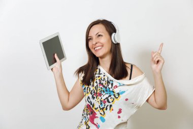 Güzel duygusal Avrupa kahverengi saçlı bir kadınla sağlıklı temiz cilt, büyüleyici smile, rahat hafif kıyafetler giymiş, dinler ve beyaz zemin üzerine tablet ile kulaklıklar müzik hoşlanır.