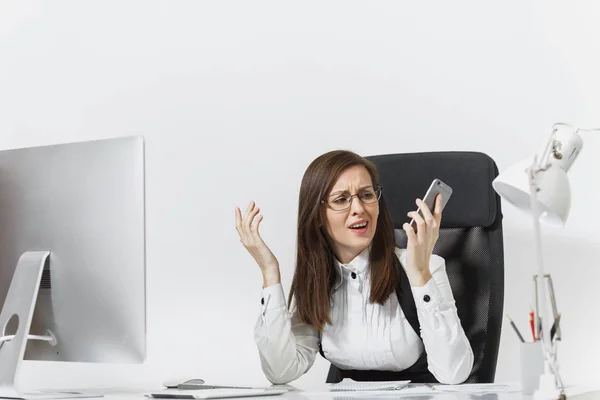 Beautiful tired and stress business woman in suit sitting at the desk, working at modern computer with documents in light office, talking on mobile phone, resolving issues on white background — Stock Photo, Image