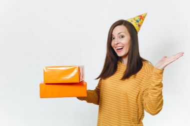 Güzel beyaz eğlenceli kutluyor ve reklam için izole beyaz arka plan üzerinde tatil keyfini mutlu kadın sarı giysili turuncu hediye kutuları ile mevcut, holding doğum günü parti şapkası.