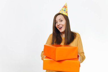 Güzel beyaz eğlenceli kutluyor ve reklam için izole beyaz arka plan üzerinde tatil keyfini mutlu kadın sarı giysili turuncu hediye kutuları ile mevcut, holding doğum günü parti şapkası.