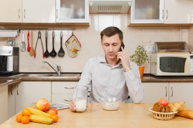 Yakışıklı genç iş adamı kahvaltı ekose gömlek içinde oturmak
