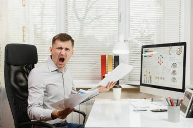 Öfkeli şok ve de oturan gömlekli bir adam iş stres