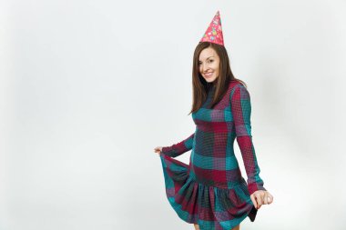 Güzel beyaz eğlenceli kutluyor ve zevk mutlu kadın ekose elbise ve doğum günü parti şapkası utangaç çekici gülümseme ve kahverengi saç, tatil için reklam izole beyaz arka plan üzerinde.