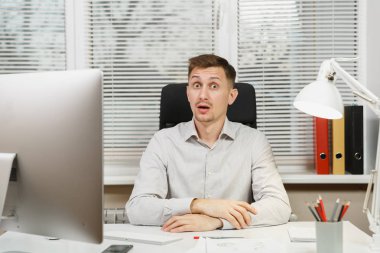 Çapraşık şok ve bilgisayarda çalışan modern monitör, klasörler, lamba, belge penceresi arka plan üzerinde ışık Office ile iş adamı masa başında oturan gömlek stres. Yöneticisi veya alt.