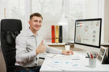 Danışma, gösteri oturan gömlek gülümseyen yakışıklı iş adamı