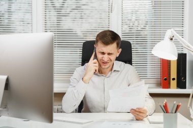 Çalışma ile modern sınıf başkanı bilgisayar, ışık office belgelerinde, sorunlarını, Masa başında oturan gömlek konuşmak, küfür ve üstünde hareket eden telefon, çığlık ciddi kızgın stres iş adamı çözme.