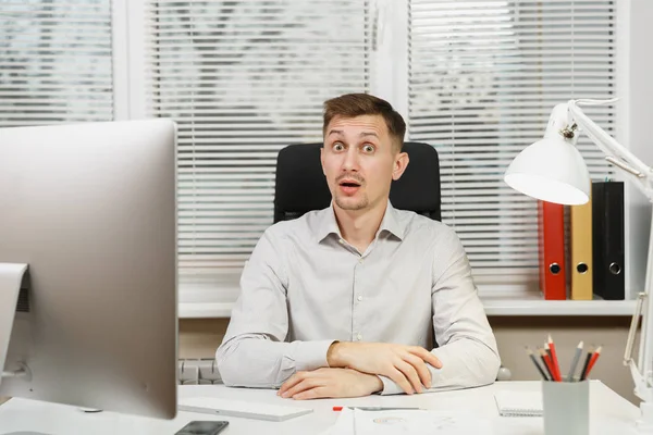 Çapraşık şok ve bilgisayarda çalışan modern monitör, klasörler, lamba, belge penceresi arka plan üzerinde ışık Office ile iş adamı masa başında oturan gömlek stres. Yöneticisi veya alt.