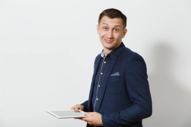 Beyaz genç iş adamı mavi Klasik takım elbise ve holding ve beyaz arka plan üzerinde izole tablet çalışan gömlek gülümseyen yakışıklı profesyonel. Yöneticisi veya işçi. Kopya alanı reklam için.