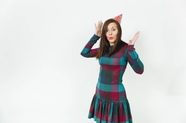 Güzel beyaz eğlenceli kutluyor ve zevk mutlu kadın ekose elbise ve doğum günü parti şapkası utangaç çekici gülümseme ve kahverengi saç, tatil için reklam izole beyaz arka plan üzerinde.