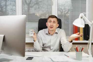 Bilgisayarda çalışan modern monitör, lamba, belge penceresi arka plan üzerinde ışık Office ile şok ve çapraşık iş adamı ile çok nakit para, Masa başında oturan gömlek. Yöneticisi veya alt