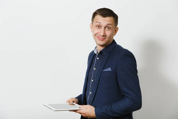 Guapo profesional sonriente caucásico joven hombre de negocios en traje clásico azul y camisa sosteniendo y trabajando en tableta aislada sobre fondo blanco. Gerente o trabajador. Copiar espacio para publicidad . —  Fotos de Stock