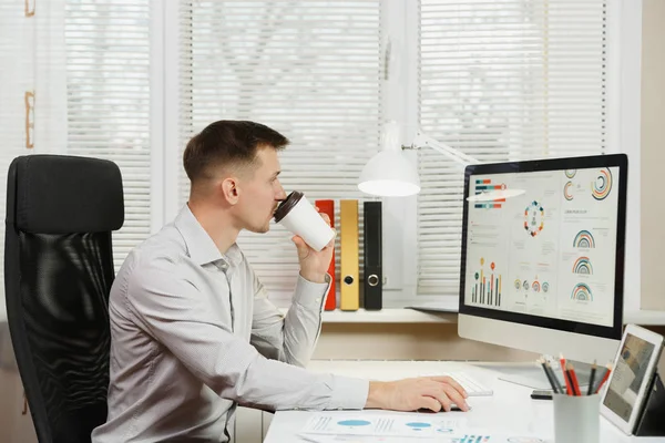 Hombre de negocios serio con camisa sentado en el escritorio, bebiendo coff — Foto de Stock