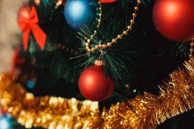 Yılbaşı ağacı süsleri cam ile yakından kırmızı, renkli mavi topları, altın gelin teli, kırmızı yay, boncuk glitter ve sıcak aydınlatma detay altın dizeleri. Yeni yıl ve tatil 2018 kavramı.