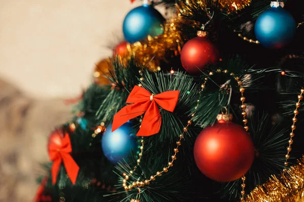 Cerrar adornos de árboles de Navidad de vidrio con bolas de color rojo, azul, oropel dorado, arcos rojos, cordones dorados de cuentas con brillo y cálidos detalles de iluminación. Año Nuevo y vacaciones 2018 concepto . — Foto de Stock